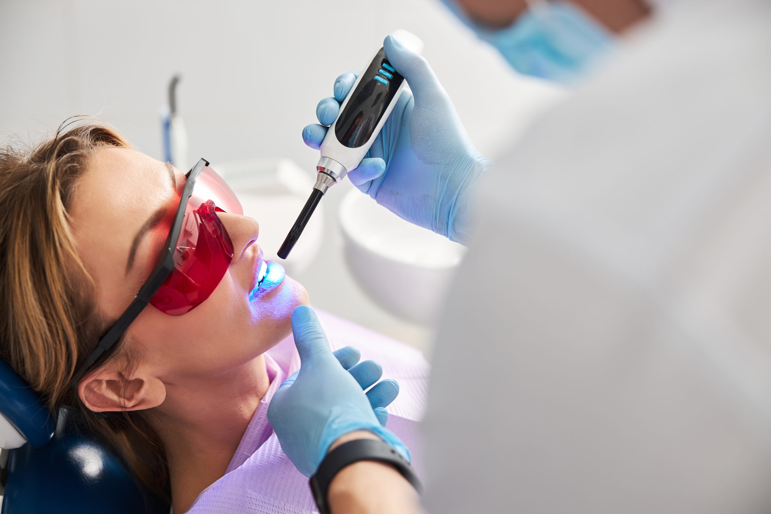 Stomatologist Setting Dental Sealants In Person Teeth
