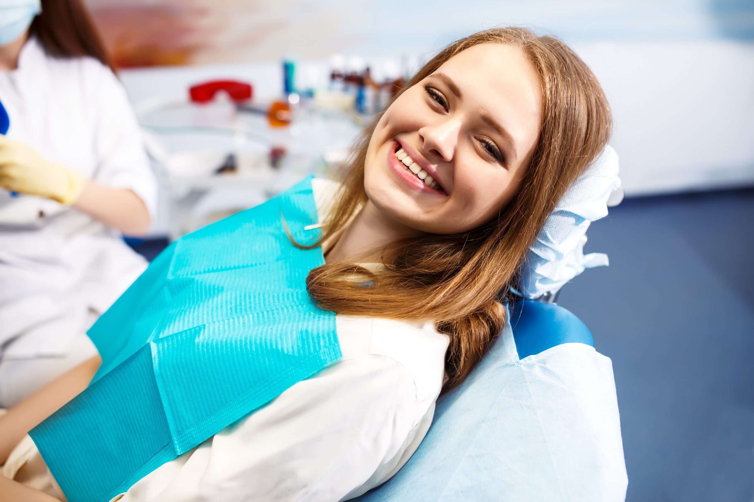 Overview Of Dental Caries Prevention. Woman At The Dentist's Chair During A Dental Procedure. Healthy Smile.